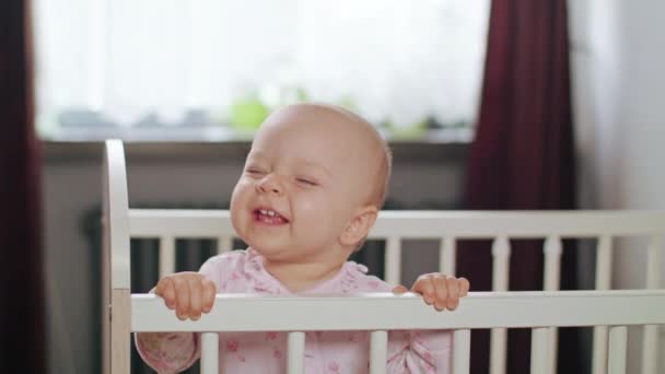 Младенец, стоящий в детской кроватке дома — стоковое видео