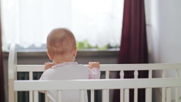 Baby steht zu Hause in der Krippe — Stockvideo