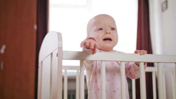 Bebê em pé em um berço em casa — Vídeo de Stock