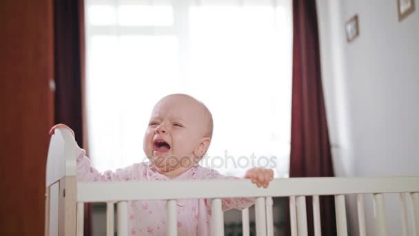 Bebé parado en una cuna en casa — Vídeo de stock