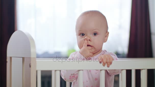 Bebé parado en una cuna en casa — Vídeo de stock