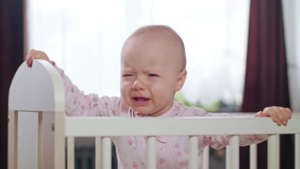 Dítě stojí v postýlce doma. Pláč — Stock video