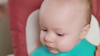 Evde bir bebek sandalyede oturan bir kız bebek