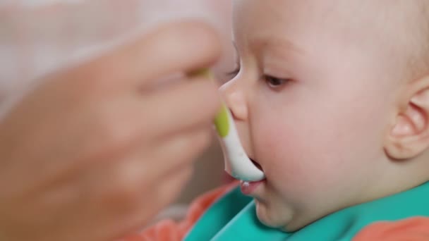 Een meisje van de Baby eten Puree thuis — Stockvideo