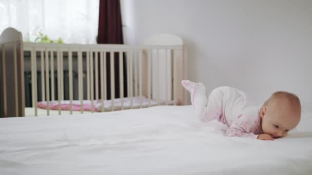 Bebé arrastrándose a cuatro patas en la cama — Vídeo de stock