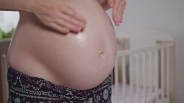 Genç hamile kadının karnı krem losyonları