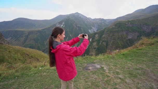 Девушка фотографирует в горах . — стоковое видео