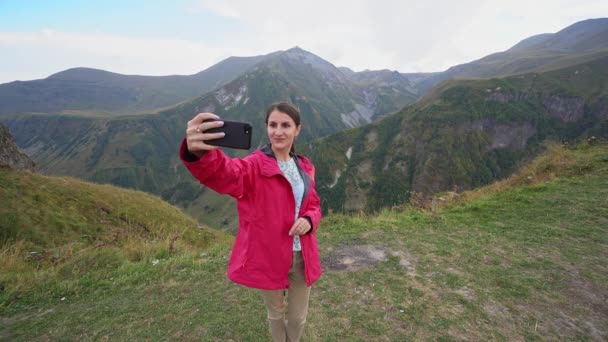 En ung dam tar Selfie i bergen. — Stockvideo