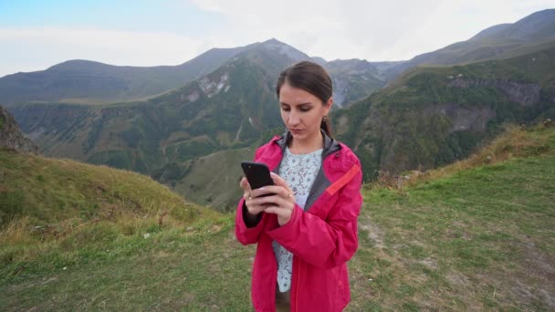 Una giovane signora che prende selfie in montagna . — Video Stock