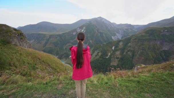 Una giovane signora in giacca rossa in montagna . — Video Stock