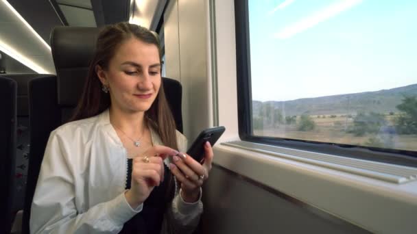 Młoda Pani z poziomu smartfona w pociągu. — Wideo stockowe