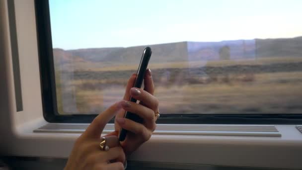 Mladé dámy ruce pomocí Smartphone ve vlaku. — Stock video
