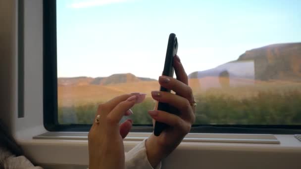 Un giovane Ladys mani utilizzando uno smartphone in treno . — Video Stock