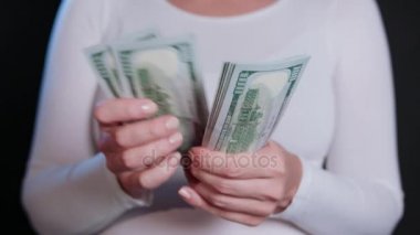 Beyaz kazaklı para tutan bir kadın