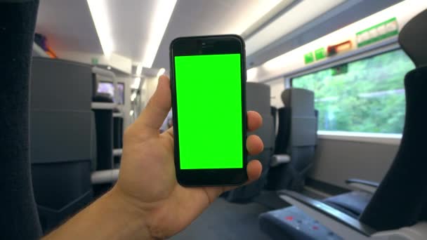 Yeşil bir ekran bir telefonla trene tutan el — Stok video