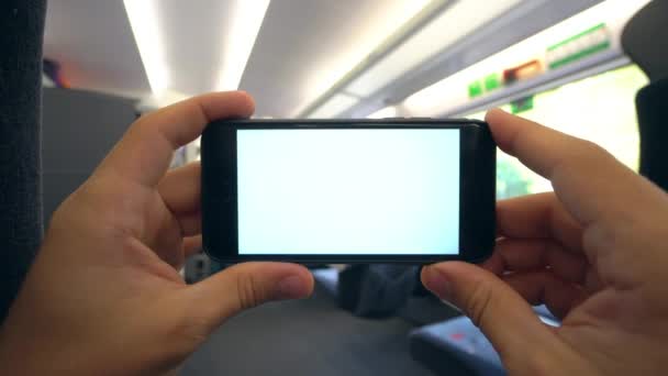 Mãos segurando um telefone com uma tela branca no trem — Vídeo de Stock