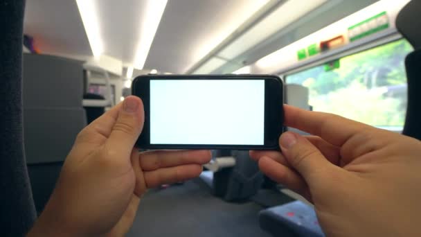 Mãos segurando um telefone com uma tela branca no trem — Vídeo de Stock