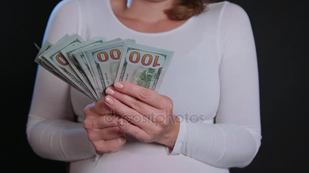 Uma mulher de camisola branca segurando dinheiro — Vídeo de Stock