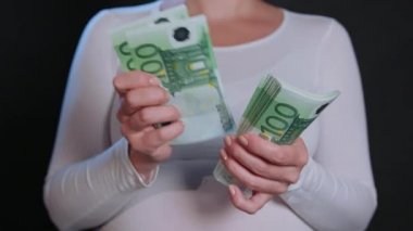 Beyaz kazaklı para tutan bir kadın