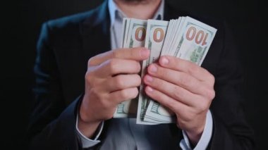 Bir adam siyah ceket ve beyaz gömlek nakit Holding