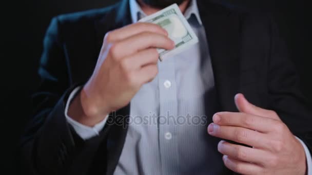 Un hombre con chaqueta negra y camisa blanca sosteniendo efectivo — Vídeos de Stock