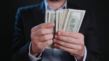 Bir adam siyah ceket ve beyaz gömlek nakit Holding