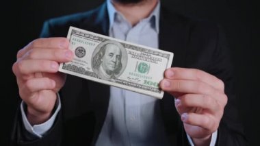 Bir adam siyah ceket ve beyaz gömlek nakit Holding