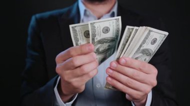 Bir adam siyah ceket ve beyaz gömlek nakit Holding