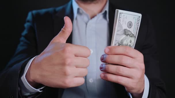 Um homem de jaqueta preta e camisa branca segurando dinheiro — Vídeo de Stock