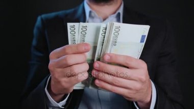 Bir adam siyah ceket ve beyaz gömlek nakit Holding