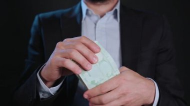 Bir adam siyah ceket ve beyaz gömlek nakit Holding