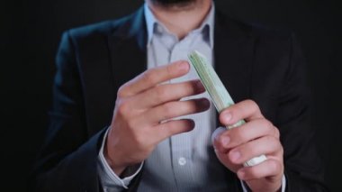 Bir adam siyah ceket ve beyaz gömlek nakit Holding