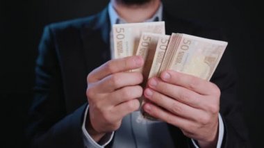 Bir adam siyah ceket ve beyaz gömlek nakit Holding