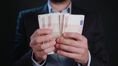 Bir adam siyah ceket ve beyaz gömlek nakit Holding