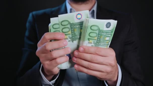 Um homem de jaqueta preta e camisa branca segurando dinheiro — Vídeo de Stock