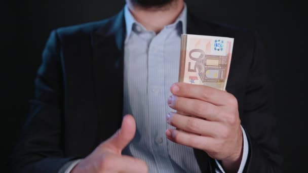 Ein Mann in schwarzer Jacke und weißem Hemd mit Bargeld — Stockvideo
