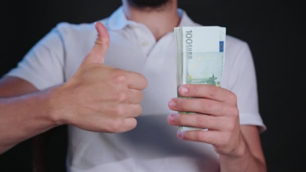 Ein Mann im weißen T-Shirt mit Bargeld — Stockvideo