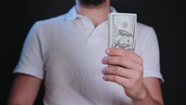 Um homem de t-shirt branca segurando dinheiro — Vídeo de Stock