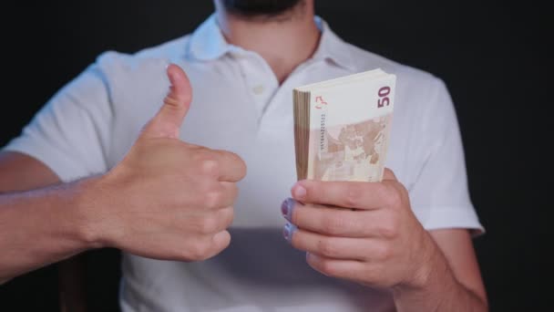 Un homme en T-shirt blanc tenant de l'argent — Video