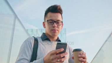 Genç bir adam dışındaki bir telefon kullanma