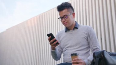 Genç bir adam dışındaki bir telefon kullanma