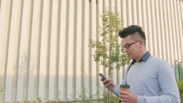 Ein junger Mann, der draußen telefoniert — Stockvideo