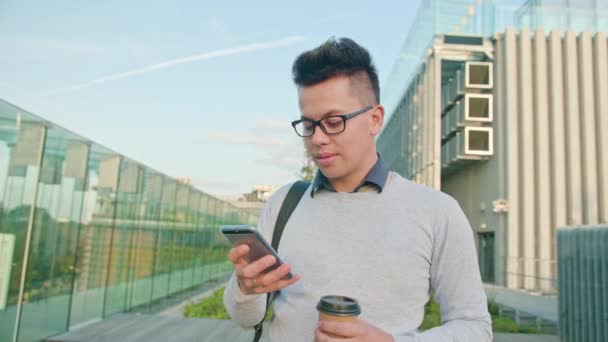 Um jovem usando um telefone fora — Vídeo de Stock