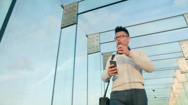 Een jonge Man lopen en met behulp van een telefoon — Stockvideo