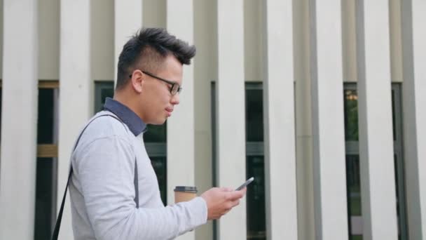 Un giovane che usa un telefono all'esterno — Video Stock