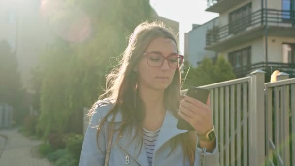 Una joven dama caminando y usando un Smartphone — Vídeo de stock