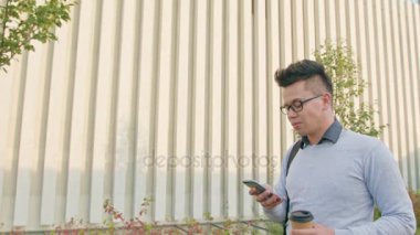 Genç bir adam dışındaki bir telefon kullanma