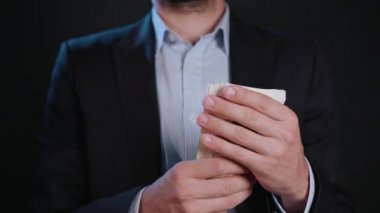Bir adam siyah ceket ve beyaz gömlek nakit Holding