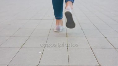 Genç bayanın ayak parke taşı üzerinde yürüme