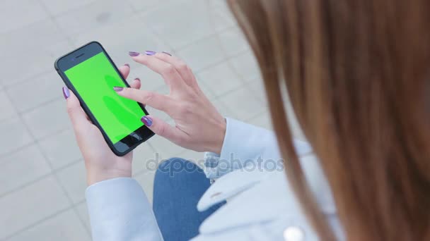 Девушка, использующая телефон с зеленым экраном — стоковое видео